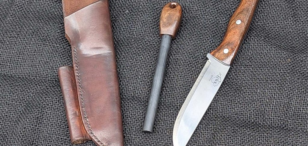 handmade custom bushcraft knife with fire steel in 1075+cr and stabilised walnut